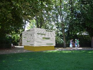 Photo de la structure qui ressemble à un gros cube blanc sur un socle en bois dans le jardin des Beaux-Arts